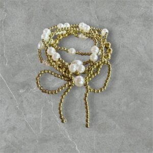 Βραχιόλι με πέρλες σε διχρωμία χρυσό και άσπρο με σχέδιο φιόγκος