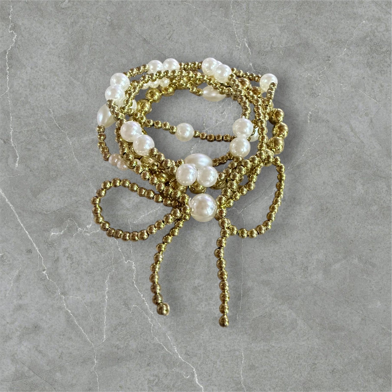Βραχιόλι με πέρλες σε διχρωμία χρυσό και άσπρο με σχέδιο φιόγκος